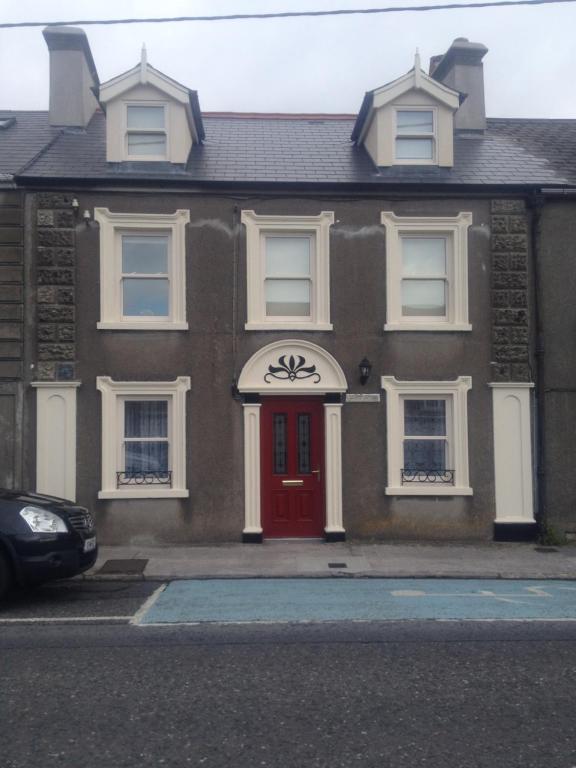 uma casa de tijolos castanhos com uma porta vermelha em Brownes Town House em Dungarvan