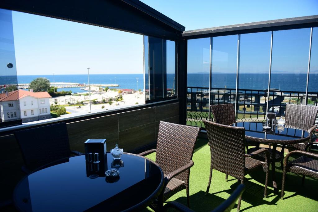 a balcony with tables and chairs and a view of the ocean at Hotel Seref in Yalova