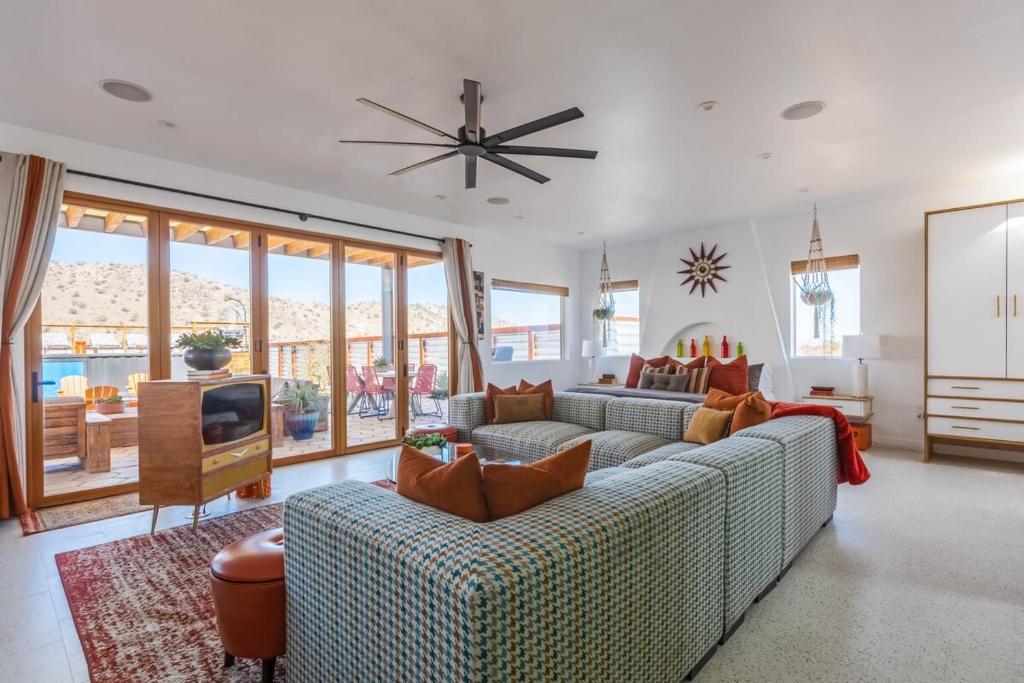 een woonkamer met 2 banken en een televisie bij Retro Vibes, Pool, Spa & Game Room in Twentynine Palms