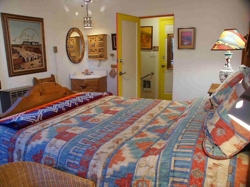 a bedroom with a bed with a colorful quilt at Inn at Halona in Zuni