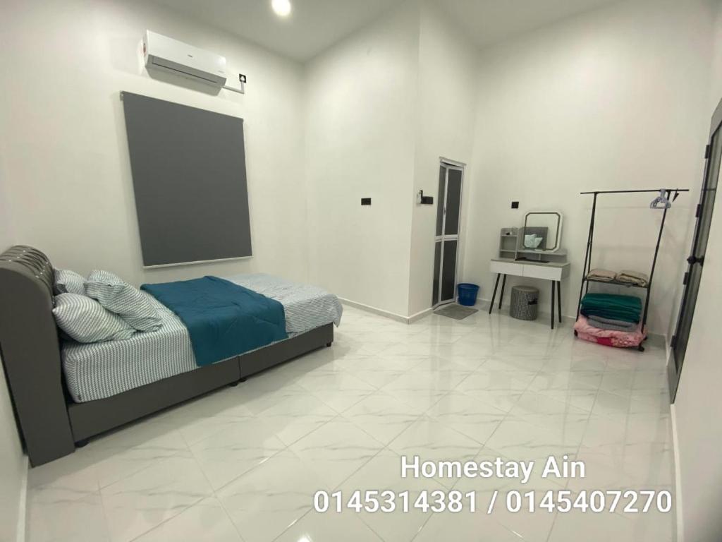 a bedroom with a bed in a white room at Homestay Ain in Kuala Terengganu