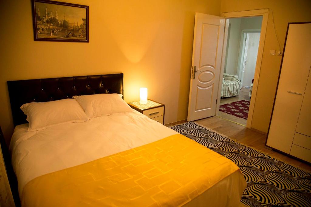 イスタンブールにあるVilla Park Apartのベッドルーム1室(ベッド1台、テーブルの上にランプ付)