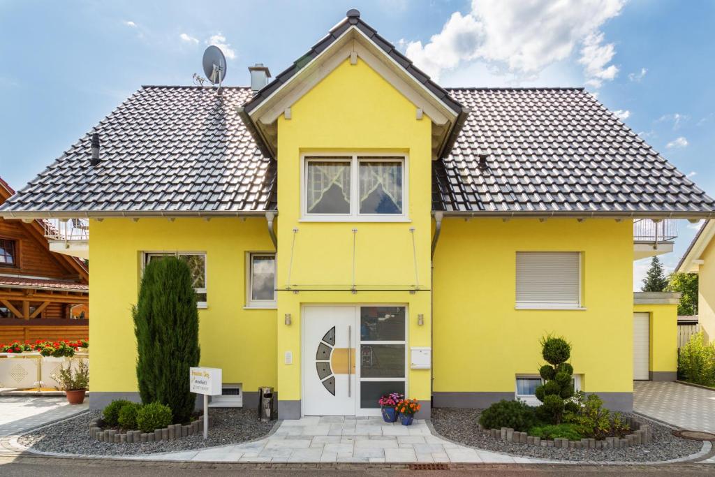 a yellow house with a black roof at Pension Sieg in Rust