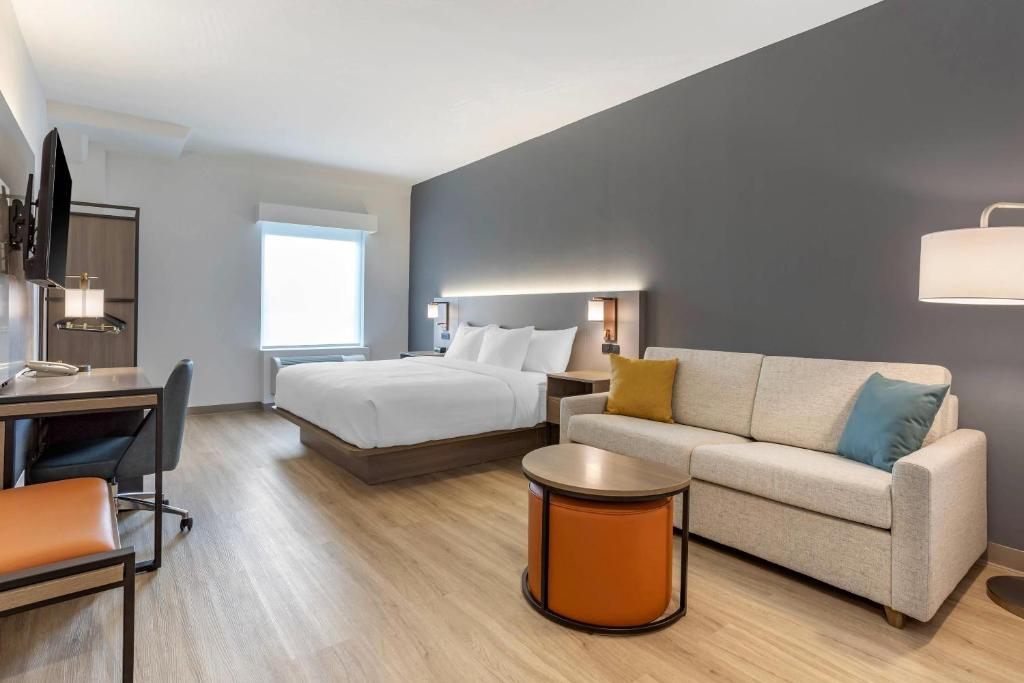 a hotel room with a bed and a couch at Comfort Inn & Suites Newark Liberty International Airport in Newark