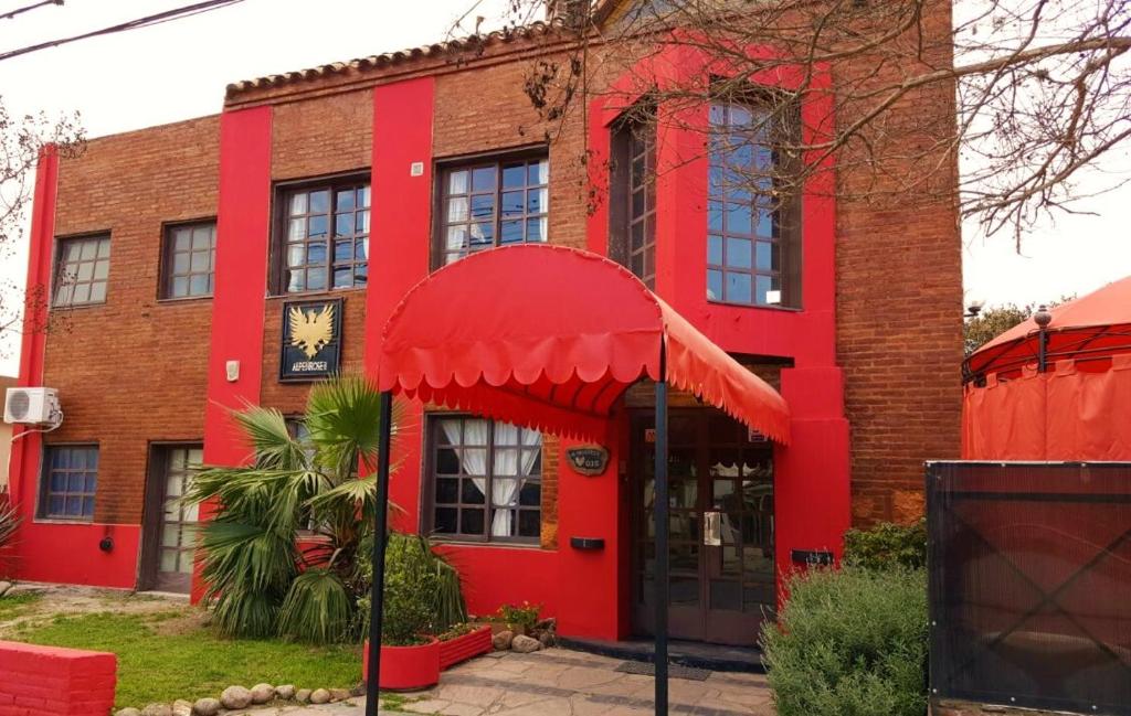 un edificio de ladrillo rojo con un reloj en él en Posada Alpenrose Neu en Villa Carlos Paz
