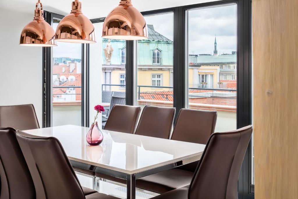 une salle à manger avec une table, des chaises et une grande fenêtre dans l'établissement Templova 6 Old Town Apartment, à Prague