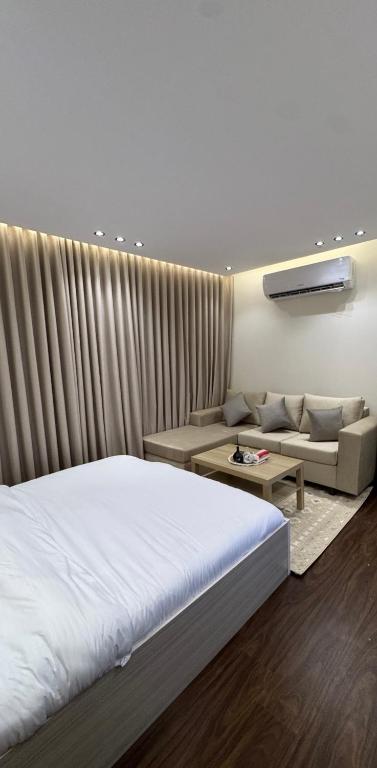 a bedroom with a white bed and a couch at شقة استديو- السليمانية in Riyadh