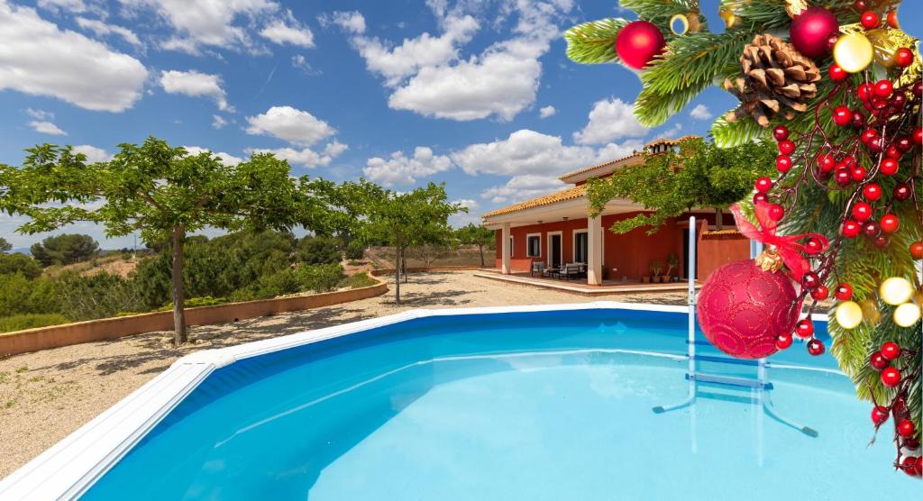 a pool with a christmas tree next to a house at Hilltop Haven by Fidalsa in Aledo