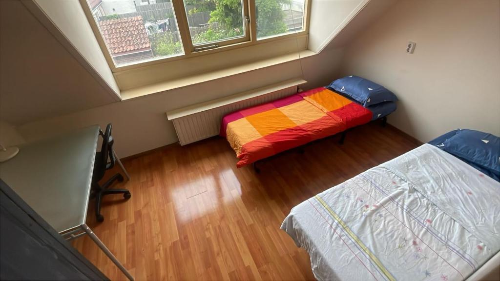 a small room with two beds and a window at Homestay Room in Utrecht