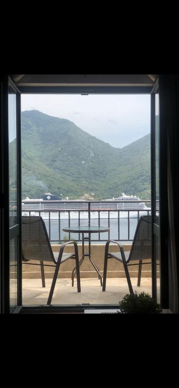 a window with two chairs and a view of a pier at Apartman Herceg Novi Capital in Kamenari