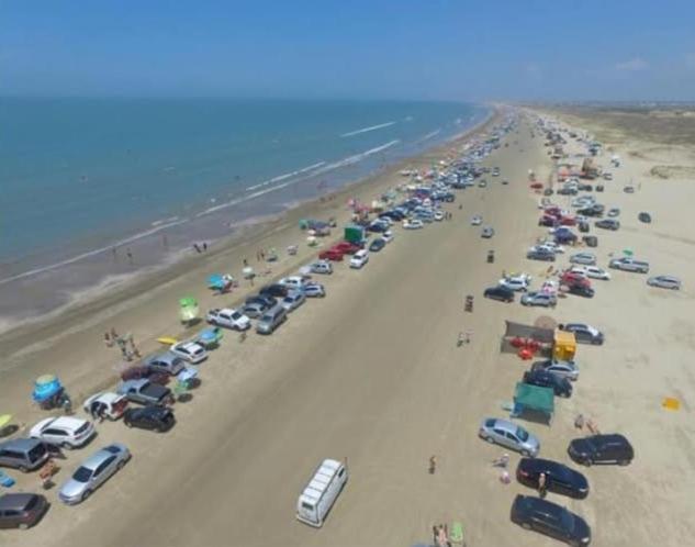 Casa en Barra del Chuy-Alvorada reserva con Seña !! في بارا ديل تشوي: مجموعة سيارات متوقفة على شاطئ