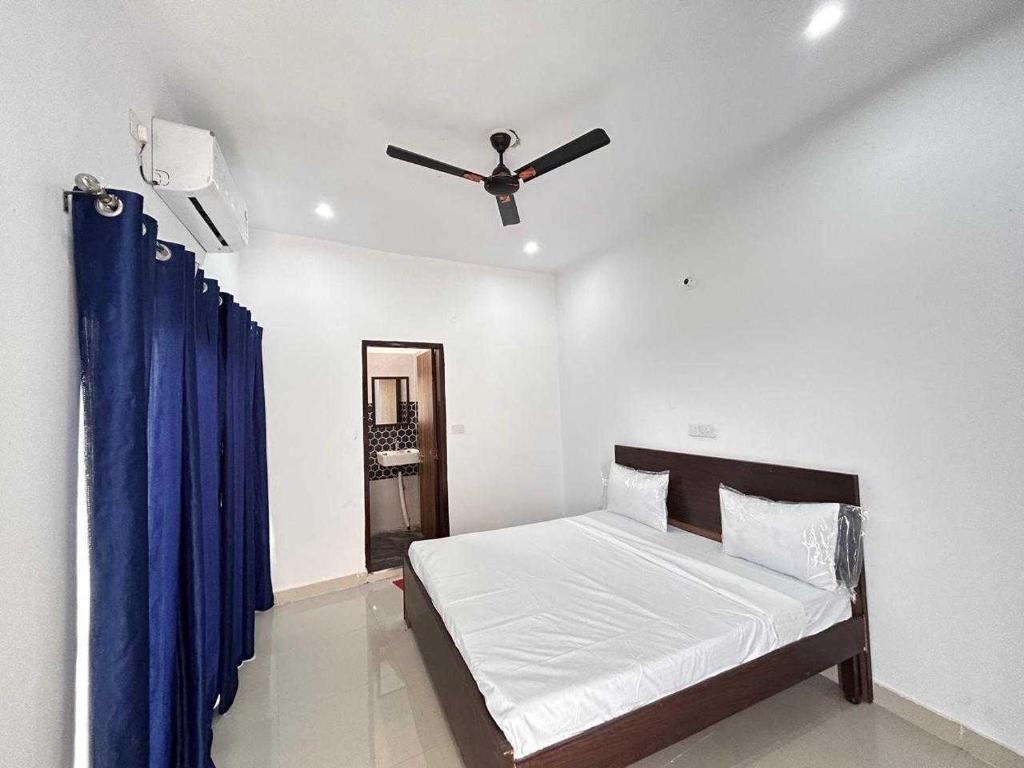 a bedroom with a bed with a ceiling fan at Hotel O SGT University Road Formerly Budhera in Dhankot