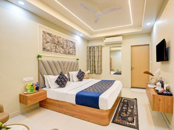 a bedroom with a large bed and a television at Hotel Aero Home in Behror