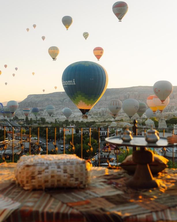 eine Menge Heißluftballons, die am Himmel fliegen in der Unterkunft Nora Cave House in Goreme