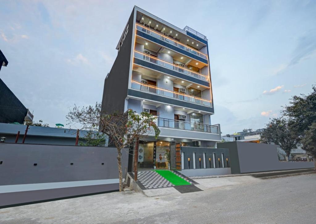 un edificio alto con un albero di fronte di Hotel La Corporate Suite a Noida