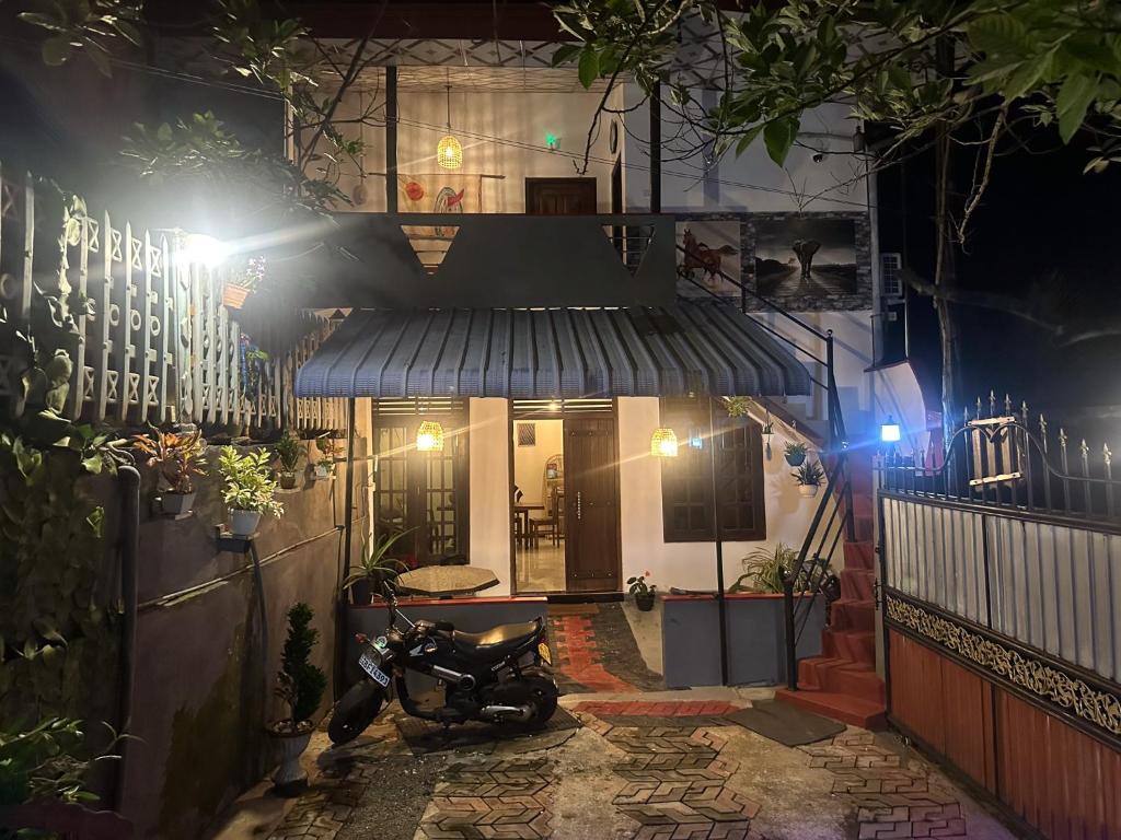 a motorcycle parked in front of a building at night at Stay Happy at Chathurni Villa, Ahangama in Ahangama
