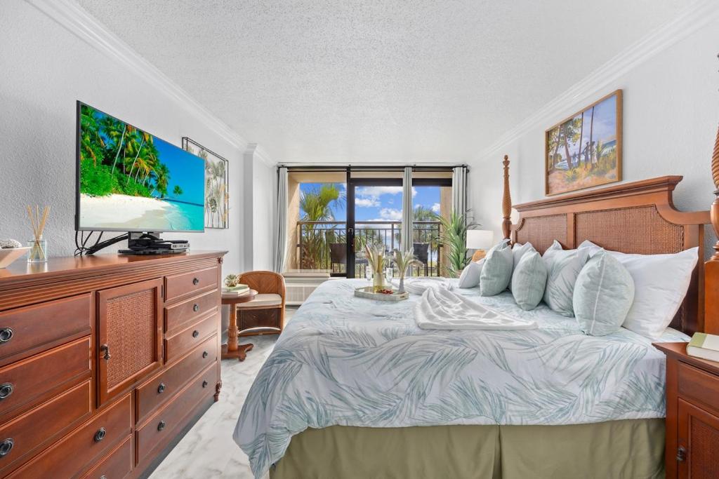 Schlafzimmer mit einem Bett, einem TV und einer Kommode in der Unterkunft Holiday Pavilion 208 in Myrtle Beach