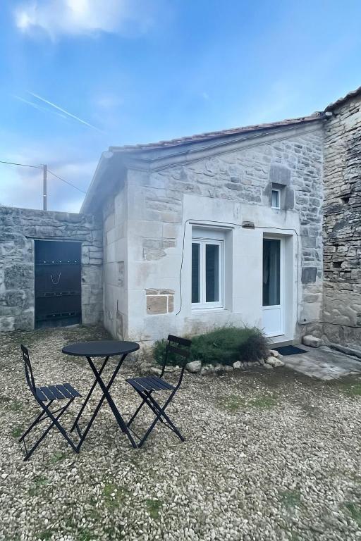 a table and two chairs in front of a building at Charmant studio avec mezzanine - proche de Angoulême in Saint-Saturnin