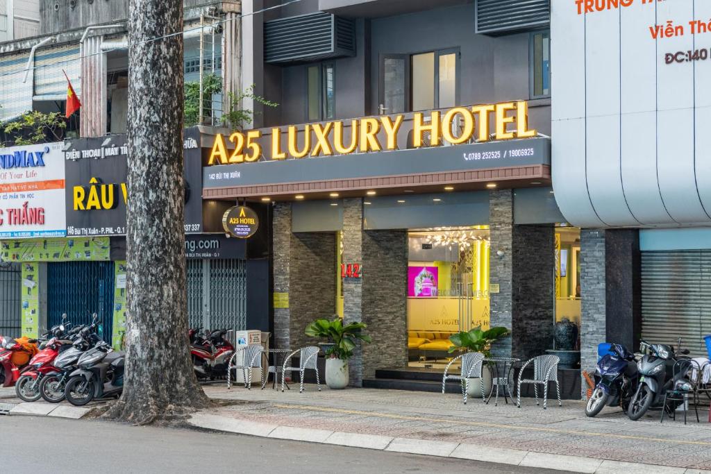 ホーチミン・シティにあるA25 Hotel - 142 Bùi Thị Xuânの高級ホテルの外に駐車されたバイクの群れ