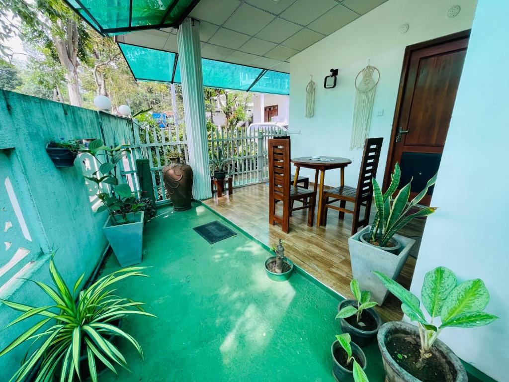 Una habitación con plantas en macetas y una mesa en un balcón. en Ritz inn Ella, en Ella