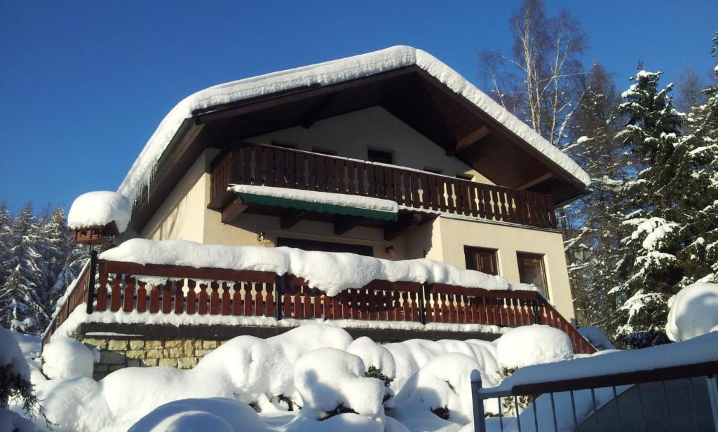 a house covered in snow with a balcony at Chata Ostrov - Eiland v srdci Českého Švýcarska in Tisá