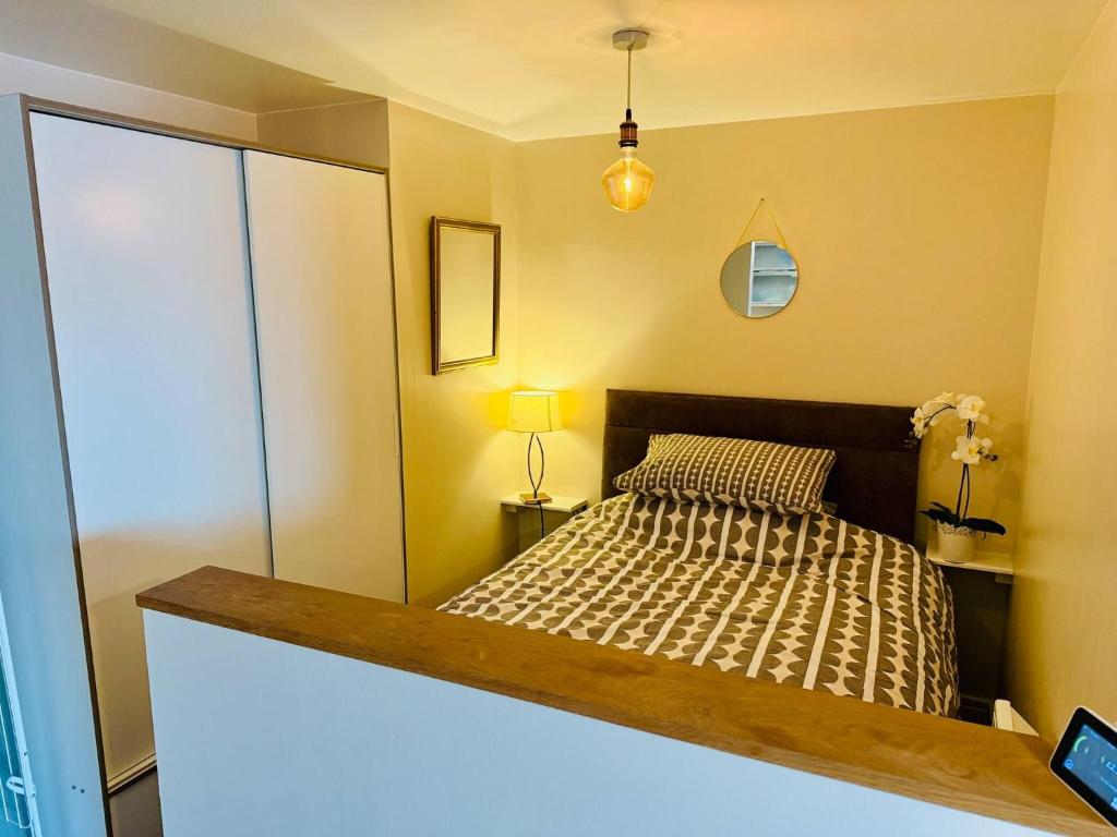 ein kleines Schlafzimmer mit einem Bett und einem Spiegel in der Unterkunft Newly Decorated Studio Apartment -City Centre- Sleeps 2 in Exeter