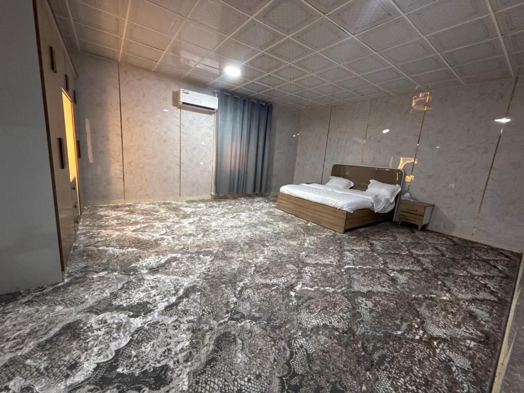 a bedroom with a bed and a floor covered in marble at Evan Rest House in Salalah