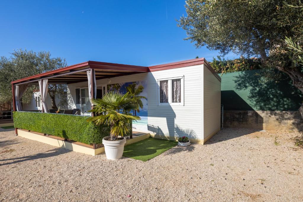 a small white house with a red roof at Seaview Beach Camp Maslina in Biograd na Moru
