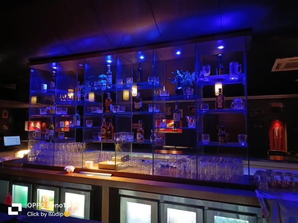 a bar with a bunch of glasses in a room at Genesis Retreat in Dāvangere