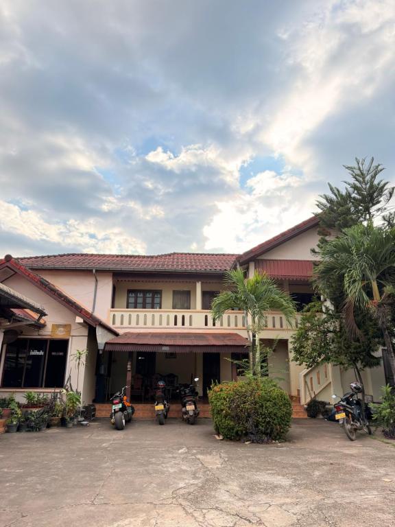 a group of motorcycles parked in front of a building at Singxay guesthouse ເຮືອນພັກສິງໄຊ 