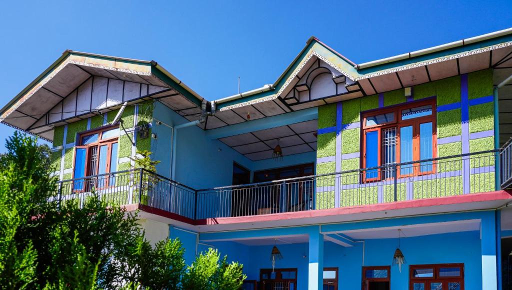 a colorful house with a balcony at Summer Guest House in Chauntrā
