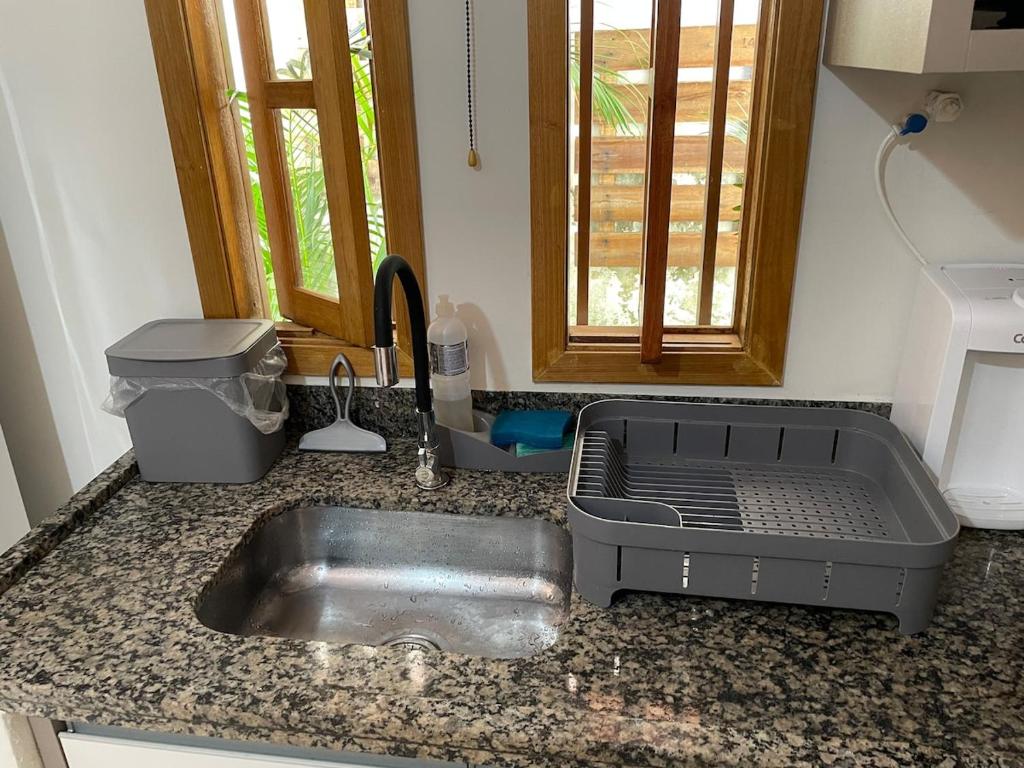 eine Küchentheke mit Spüle und Fenster in der Unterkunft Recanto do Calango in Lajeado