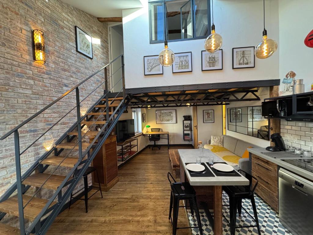 RouffiacにあるBienvenue à l'Atelier Eiffelの階段のあるロフトとテーブルのあるキッチン