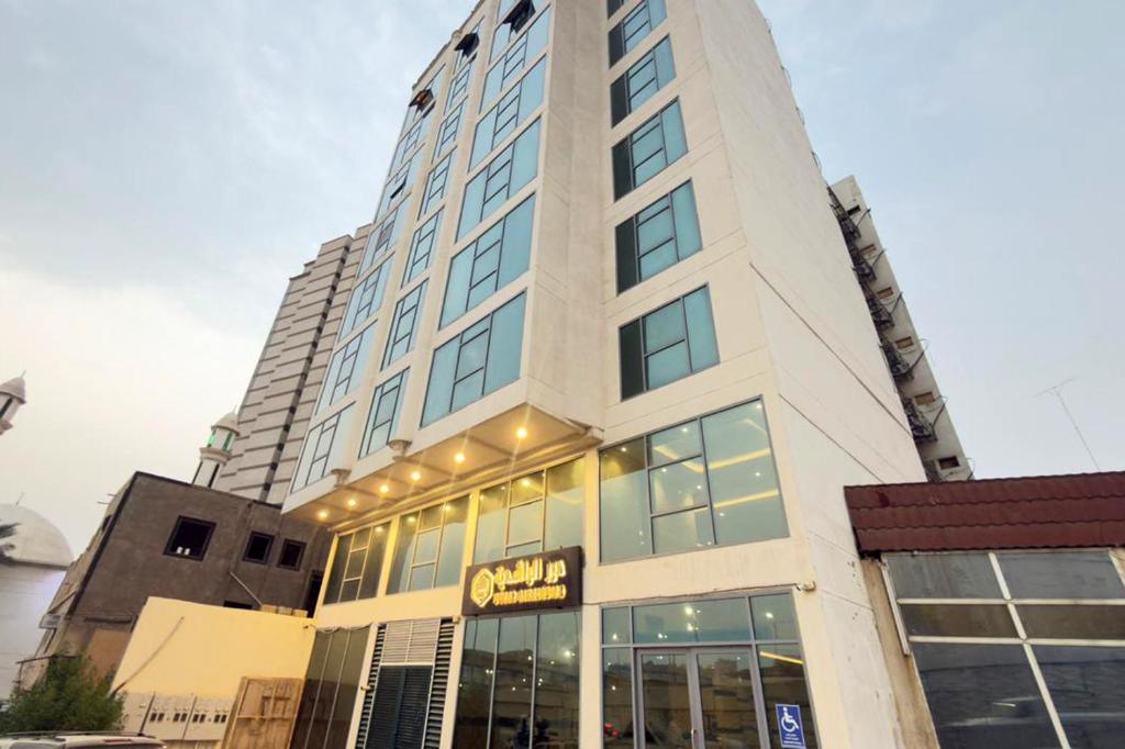 Az Zahrāʼにあるفندق درر الراشديةの前に看板がある高い建物