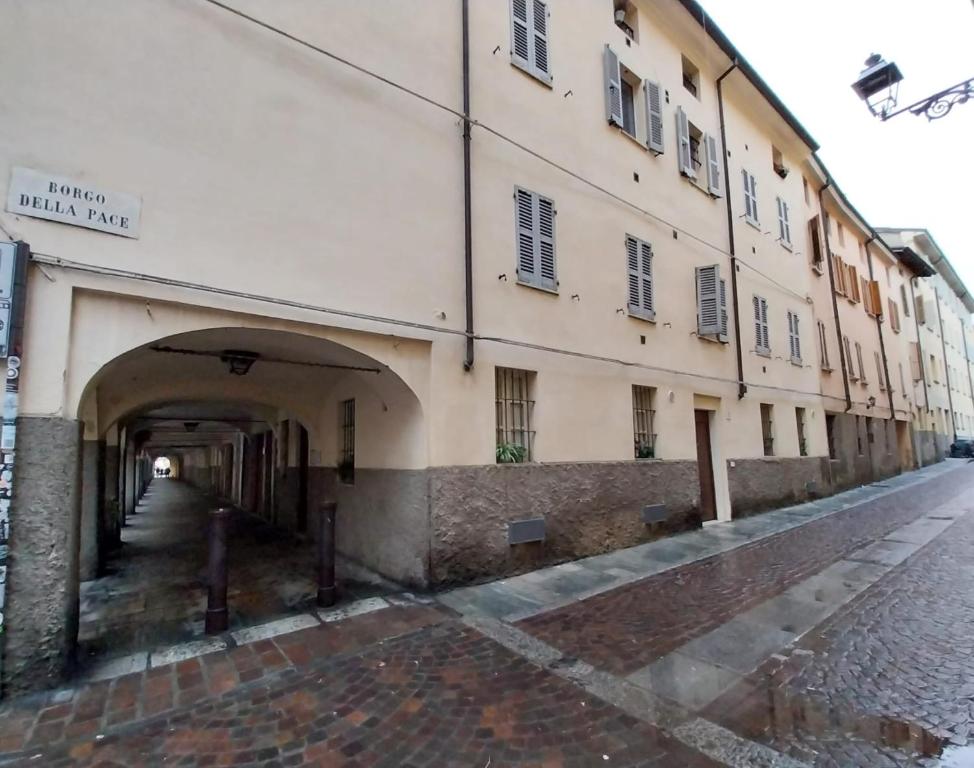 a building with an archway next to a street at Borgo delle Colonne 22 in Parma