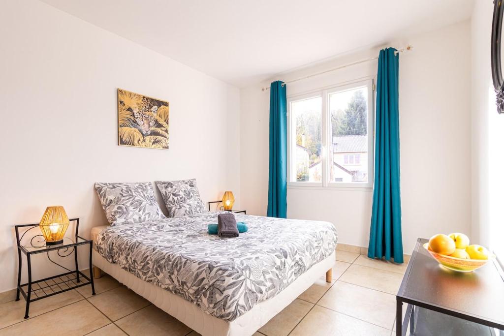 une chambre avec un lit et une fenêtre avec des rideaux bleus dans l'établissement Le Familial - Disneyland, parking gratuit, à Montry