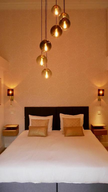 a bedroom with a large white bed with lights at B&B Natuurlijk Harderwijk in Harderwijk