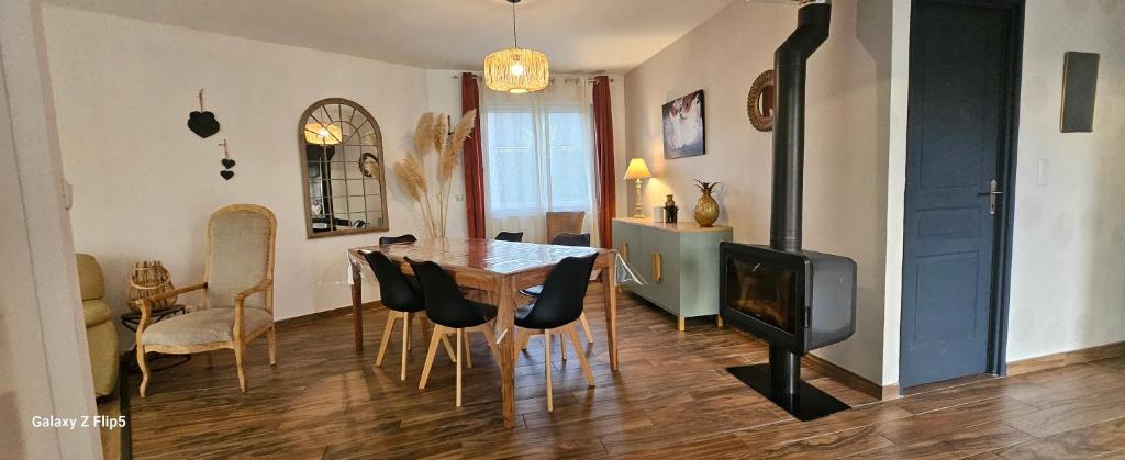 ein Wohnzimmer mit Esstisch und Stühlen in der Unterkunft Comme à la maison in Corneville-sur-Risle