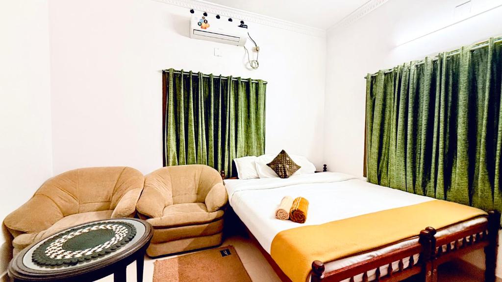 Un dormitorio con una cama, una silla y un sofá. en Comodita Inn, en Ernakulam