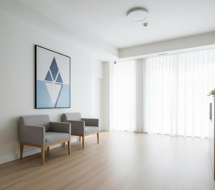 a living room with two chairs and a picture on the wall at Doksanlar Apart 