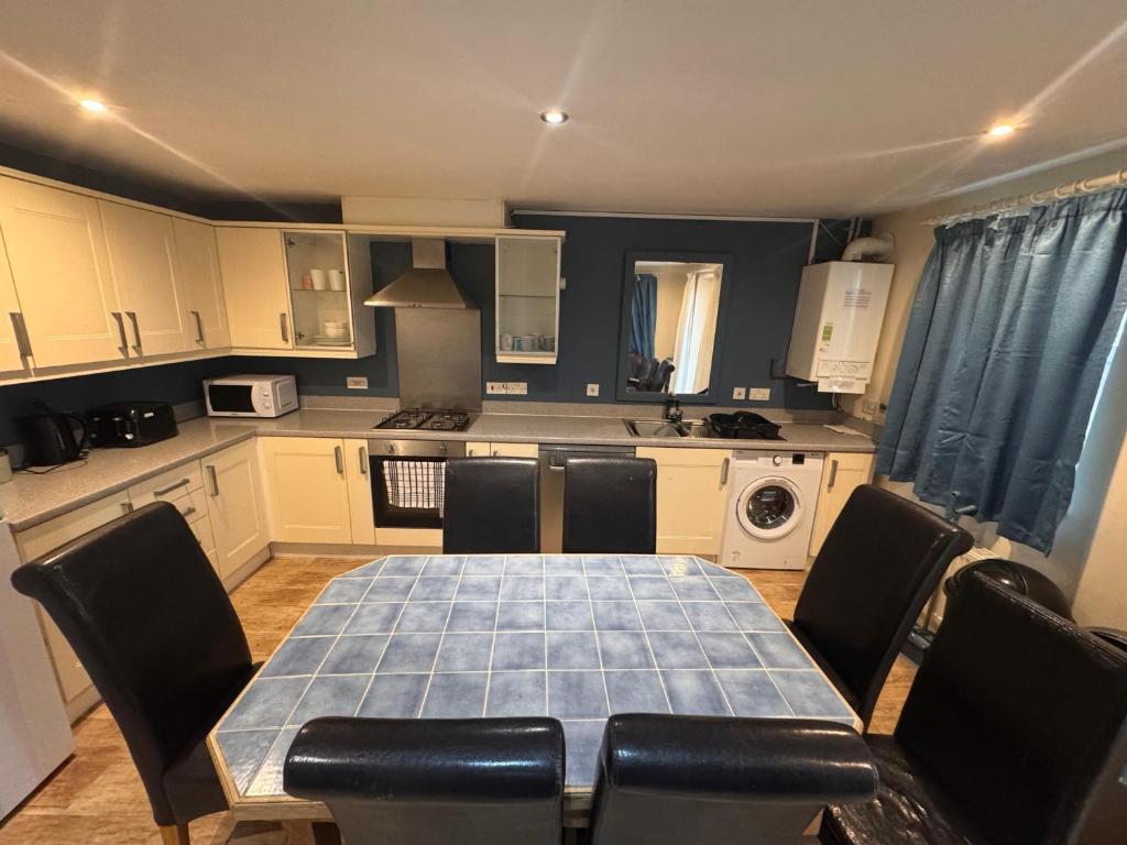 Una cocina con una mesa y sillas en una cocina. en Valley View Guest House, en Newcastle-under-Lyme