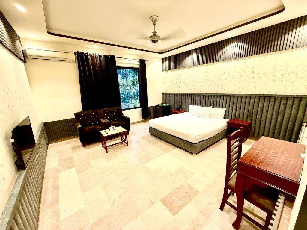 a bedroom with a bed and a couch and a table at Blue Moon Residency Jinnah Super in Islamabad