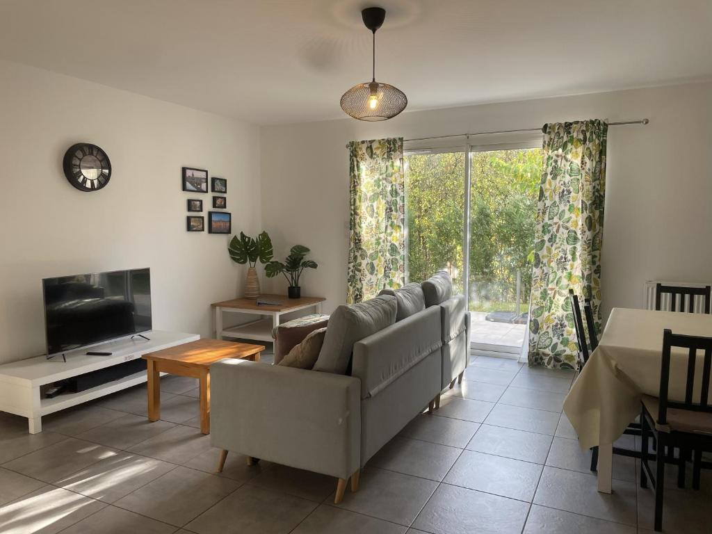 a living room with a couch and a tv at Les Villas de Castel - villa "Les Muriers" in Castelmaurou