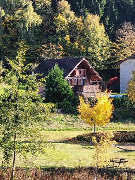 une maison au milieu d'une cour avec un banc dans l'établissement Le Saptésien, à Ban-de-Sapt