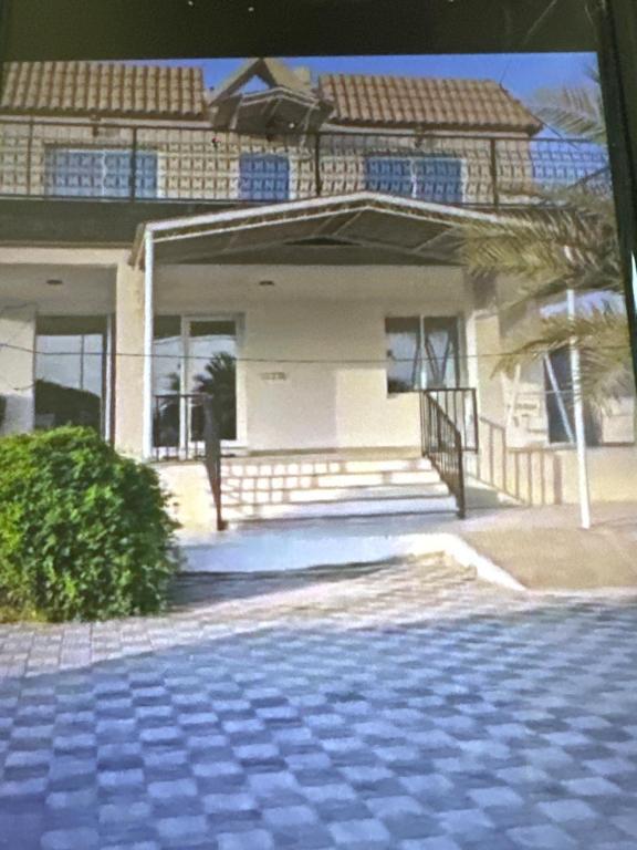 une maison avec un palmier devant dans l'établissement Abucho Holiday Homes in Ras Al Khaimah UAE, à Ras al Khaimah