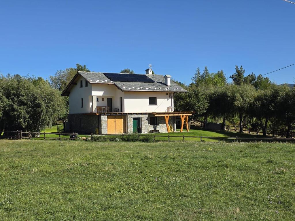 a white house on a field with a yard at Casa Luigina in Verrayes
