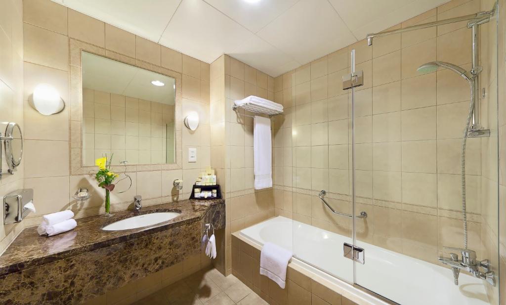 アブダビにあるアル マンゼル ホテル アパートメンツのバスルーム(バスタブ、シンク、シャワー付)