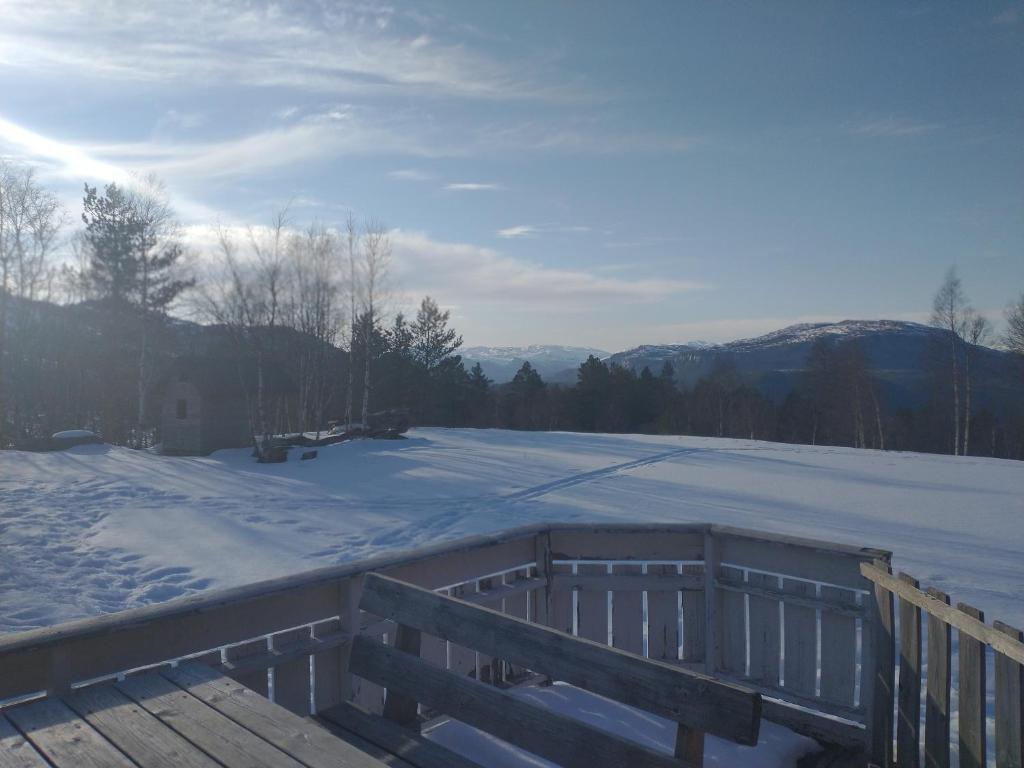 a snow covered deck with a view of the mountains at Gullingen Cabin Winter Wonderland 