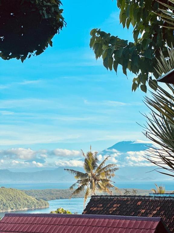 a palm tree sitting on top of a building at Ocean View Sunset Heaven in Nusa Penida