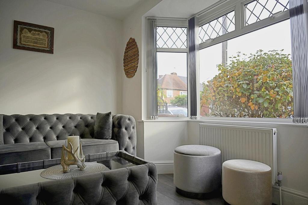 a living room with a couch and a large window at Comfortable 3-Bed Home - Driveway Parking in Long Eaton